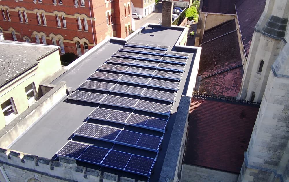 Drone view of the tilted array on the church flat roof beside the tower